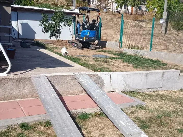 Разтоварване на минибагер с рампи в двор